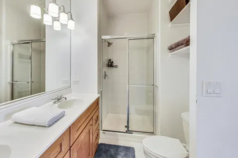 a bathroom with a sink a toilet and shower