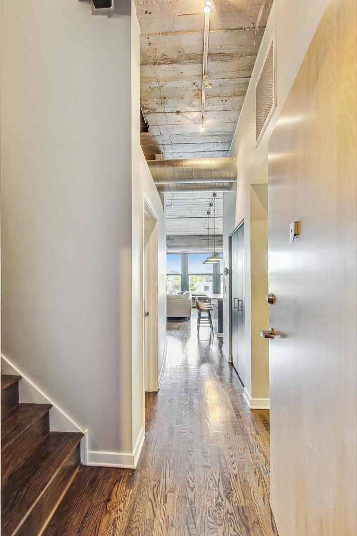 1111 West 14th Place, Unit 328 Chicago, IL 60608 - Photo 10 of 49 a view of a hallway view with wooden floor and staircase