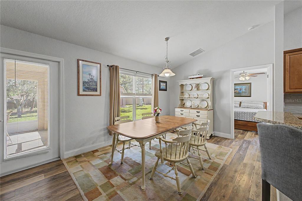 11213 Flock Avenue Weeki Wachee, FL 34613 - Photo 13 of 46 a view of a dining room with furniture and wooden floor