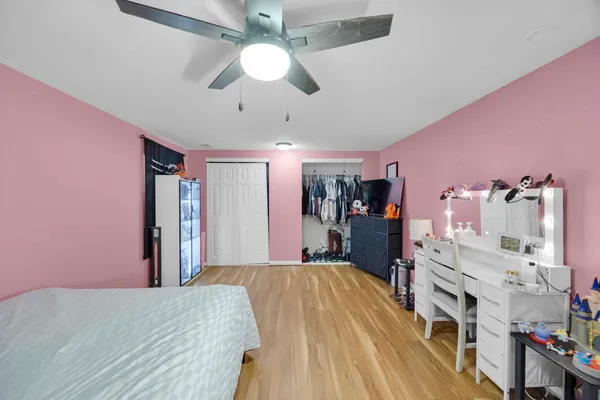 a bed room with a bed chandelier and a flat tv screen