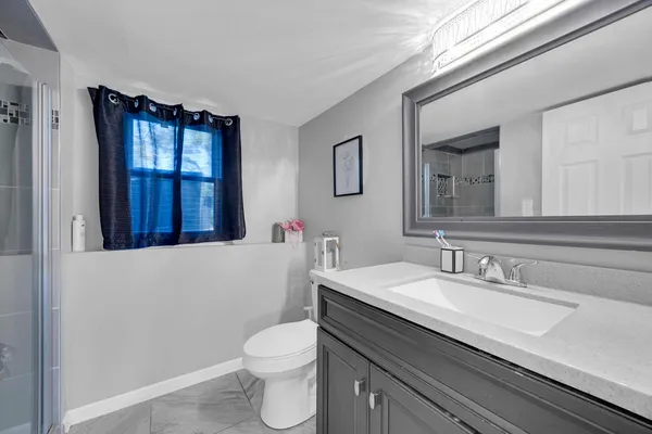 a bathroom with a sink a toilet and mirror
