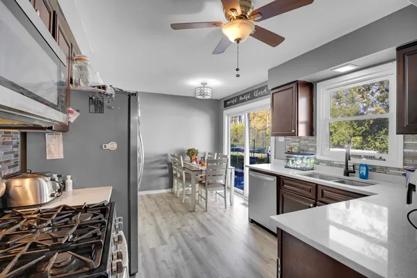 a kitchen with stainless steel appliances a table chairs and a chandelier