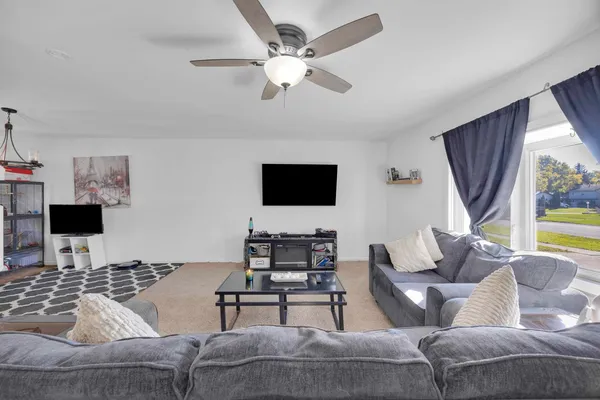 a living room with furniture a flat screen tv and a window