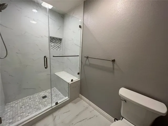 a bathroom with a shower and toilet