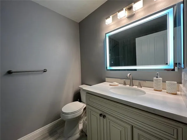 a bathroom with a toilet a sink and mirror