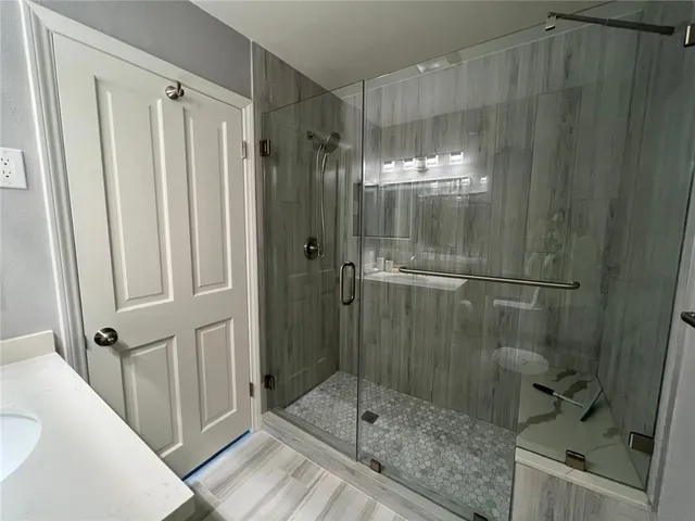 a bathroom with a shower and a sink