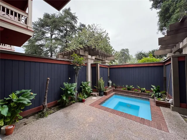 a backyard with table and chairs potted plants and wooden fence