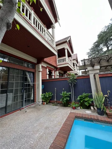 a view of a street with potted plants and a large tree