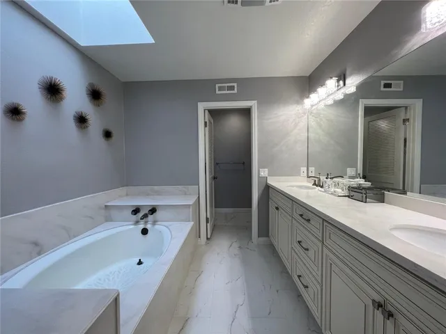 a bathroom with a tub sink and mirror