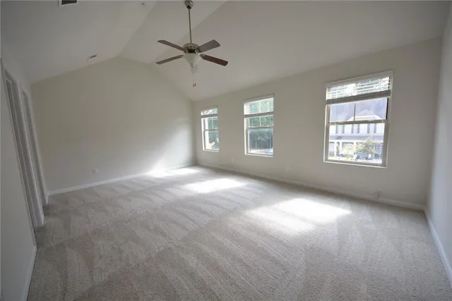 an empty room with windows and fan