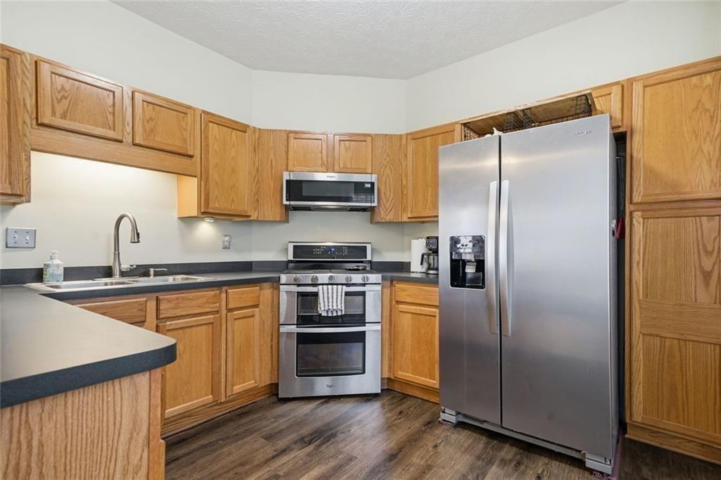 148 Timber Gate Drive Lawrenceville, GA 30045 - Photo 12 of 38 a kitchen with stainless steel appliances granite countertop a refrigerator a sink dishwasher a stove with wooden floor and cabinets