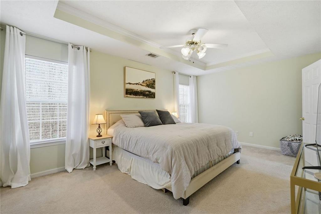148 Timber Gate Drive Lawrenceville, GA 30045 - Photo 22 of 38 a spacious bedroom with a bed and a chandelier