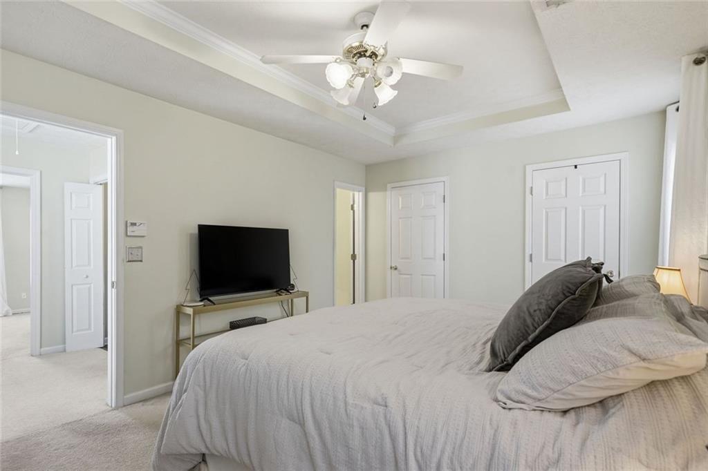 148 Timber Gate Drive Lawrenceville, GA 30045 - Photo 24 of 38 a bedroom with a bed tv and a chandelier