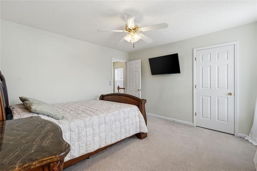 148 Timber Gate Drive Lawrenceville, GA 30045 - Photo 29 of 38 a bedroom with a bed and a flat screen tv