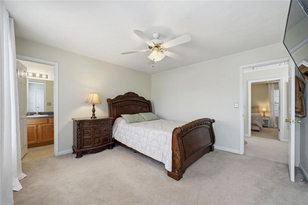 148 Timber Gate Drive Lawrenceville, GA 30045 - Photo 30 of 38 a bedroom with a bed and a chandelier