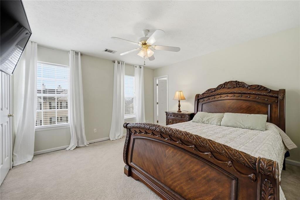 148 Timber Gate Drive Lawrenceville, GA 30045 - Photo 31 of 38 a bedroom with a bed and a chandelier