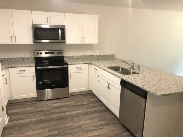 a kitchen with granite countertop a sink and a stove top oven