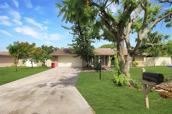 a front view of a house with a yard and trees