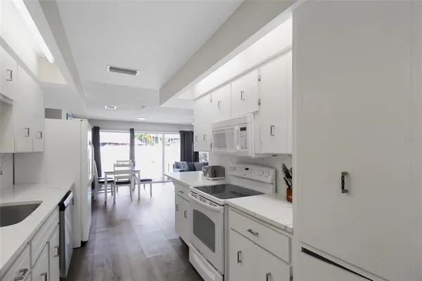 a kitchen with a sink cabinets and wooden floor