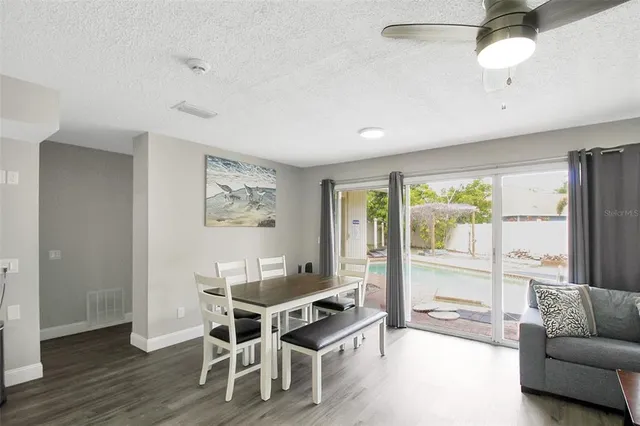 a workspace with furniture wooden floor and a chandelier fan