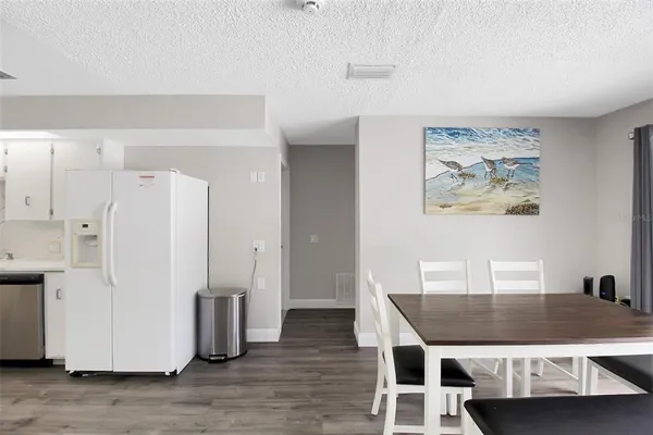 a dining room with wooden floor and white cabinet