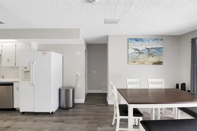 a dining room with wooden floor and white cabinet