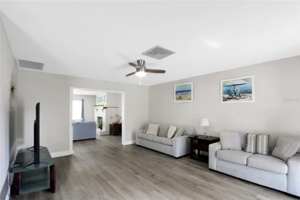 a living room with furniture and a wooden floor