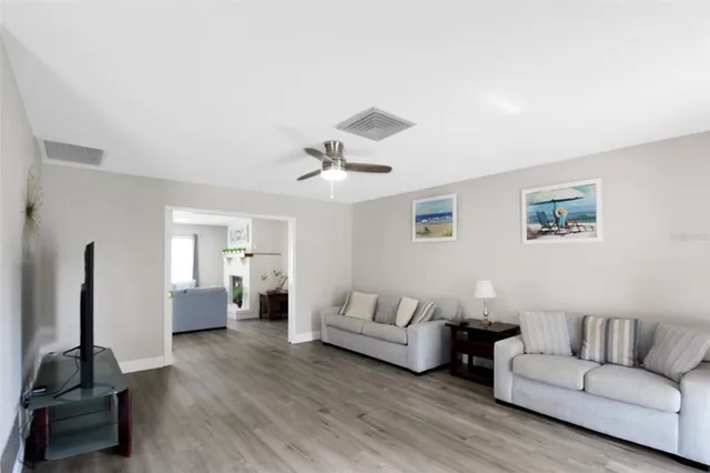 a living room with furniture and a wooden floor