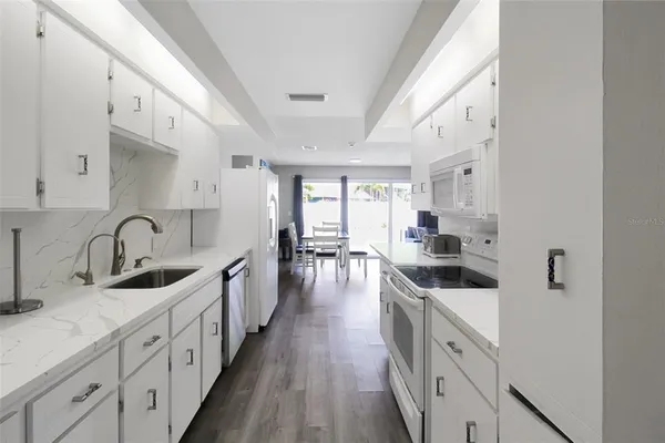 a kitchen with white cabinets sink and stainless steel appliances