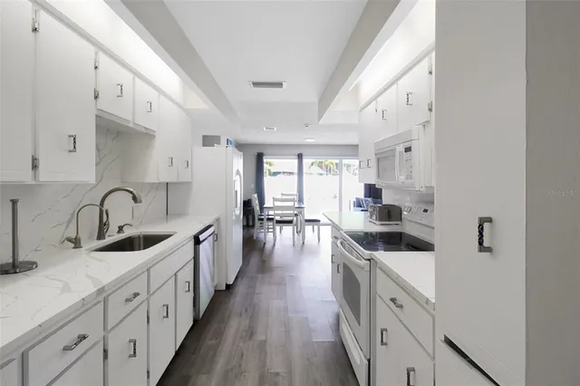 a kitchen with white cabinets sink and stainless steel appliances