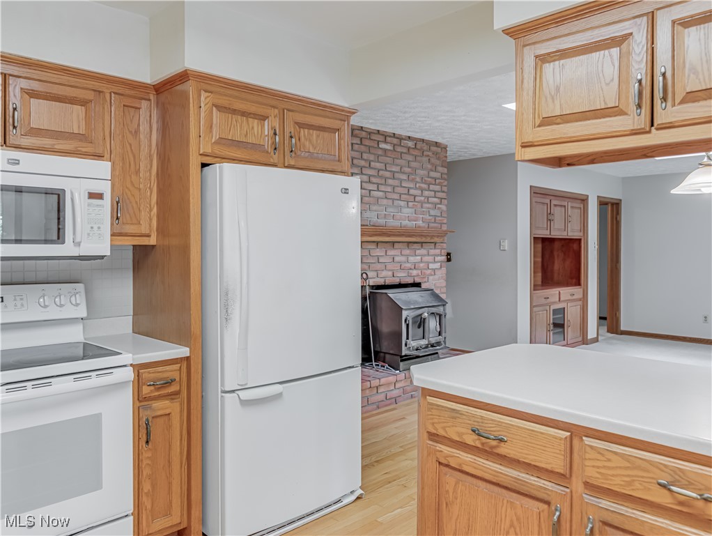 3087 Baughman Road Clinton, OH 44216 - Photo 8 of 24 Kitchen with light wood-type flooring, white appliances, and a wood stove