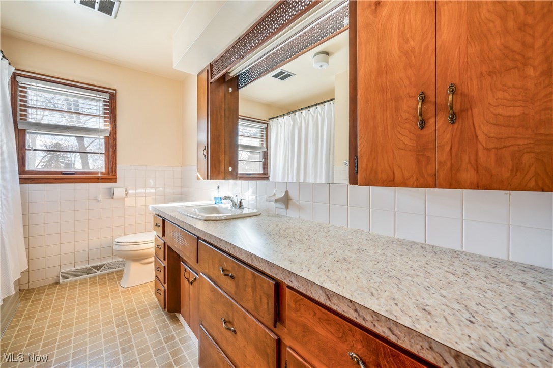 3210 Oser Road Norton, OH 44203 - Photo 31 of 47 Bathroom with tile patterned floors, vanity, toilet, and tile walls