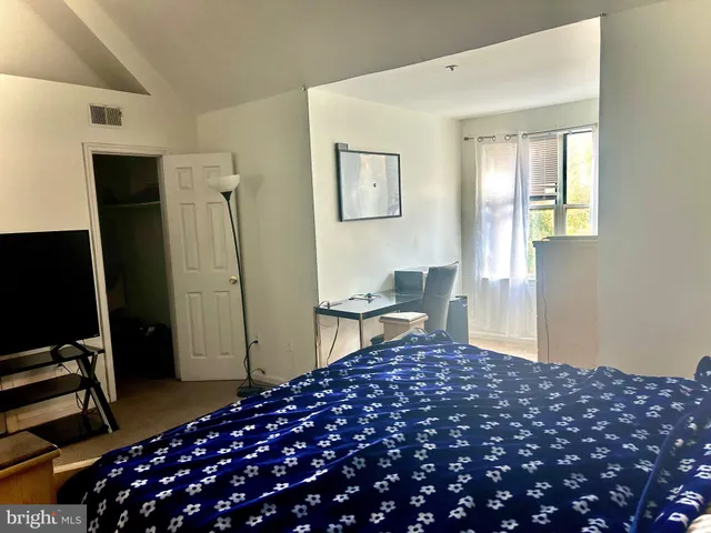 a bedroom with a bed and a flat screen tv