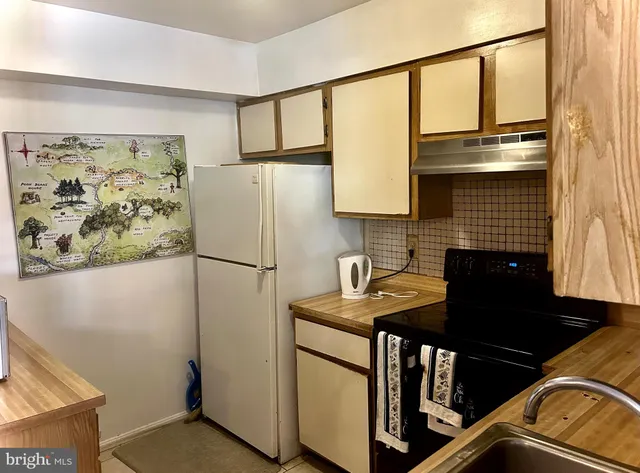 a kitchen with stainless steel appliances granite countertop a refrigerator and a stove