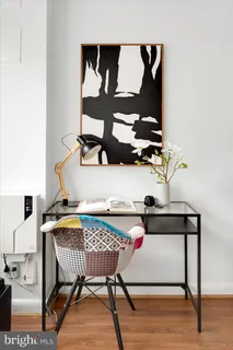 a living room with furniture a large window and wooden floor