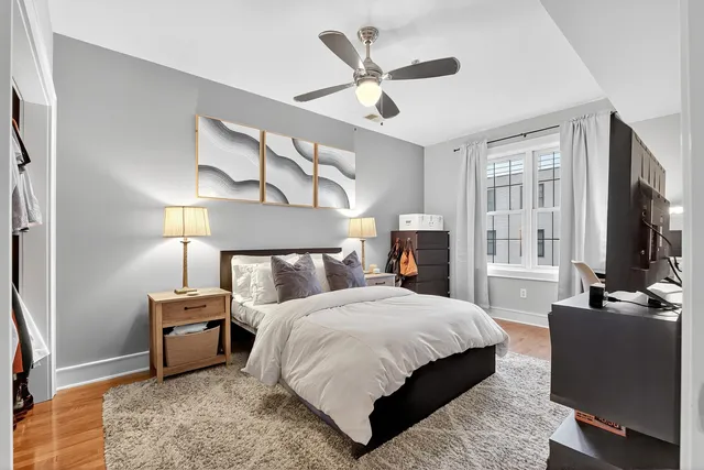 a bedroom with a bed a couch and a flat tv screen on a dresser