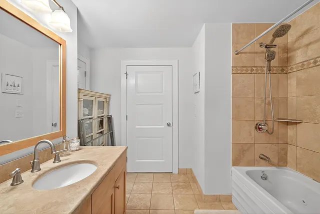 a bathroom with a granite countertop sink a mirror and a bathtub