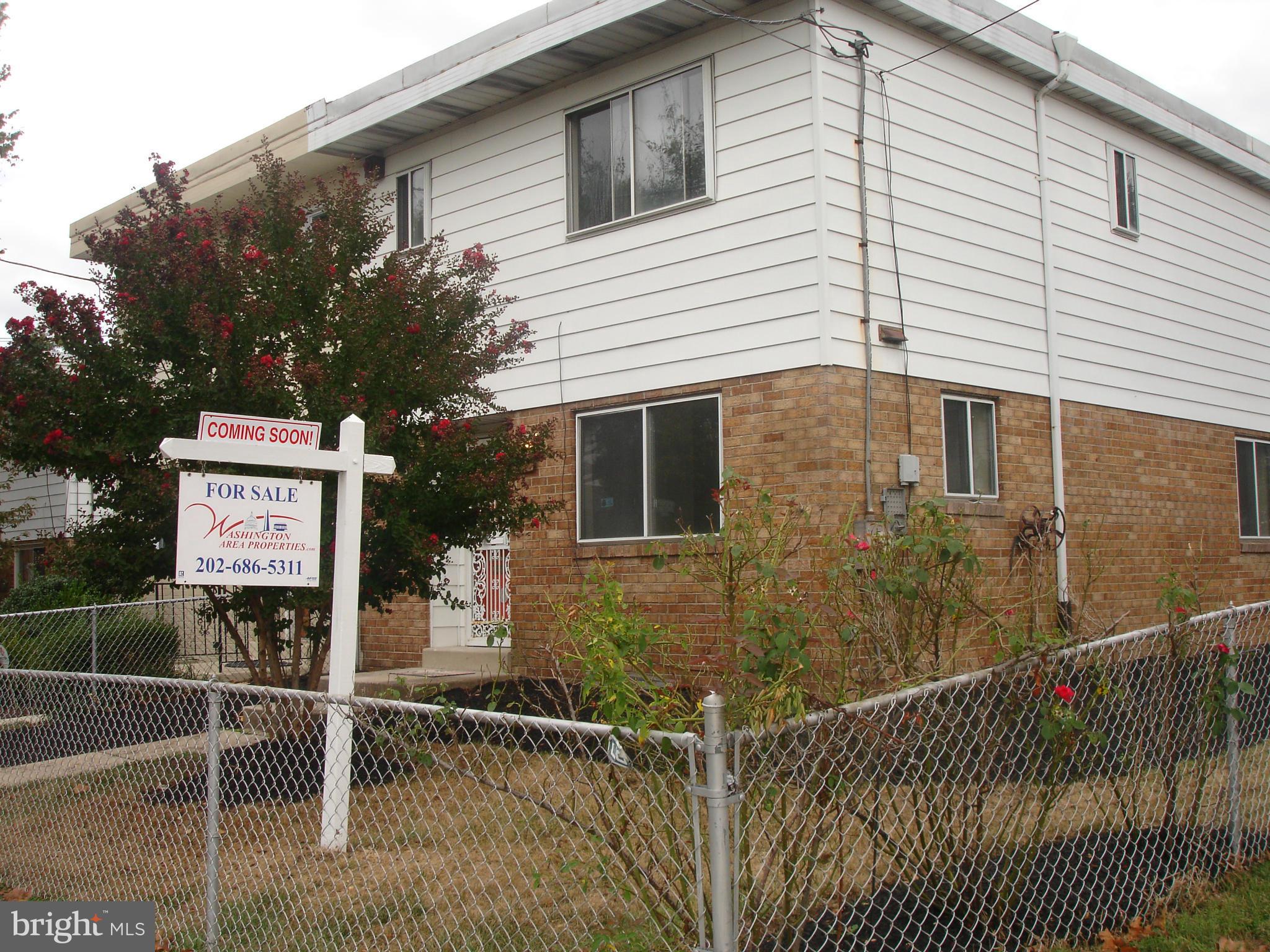 a sign on street next to a house