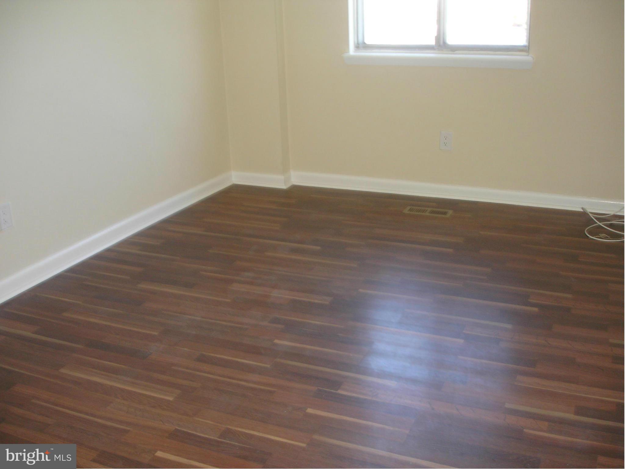 4705 Sargent Road Northeast Washington, DC 20017 - Photo 10 of 24 an empty room with wooden floor and windows