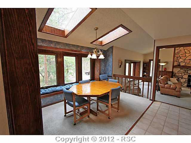 13010 Bridle Bit Road Colorado Springs, CO 80908 - Photo 17 of 25 Eat-in dining area off of the kitchen complete with skylights, a wall of windows, window bench and (not pictured) built-in desk with lighting and cabinets. PERFECT for entertaining!
