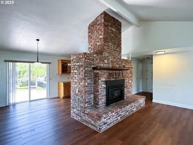 a living room with a fireplace and wooden floor