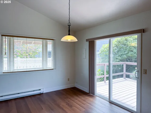 a view of a room with wooden floor and a window