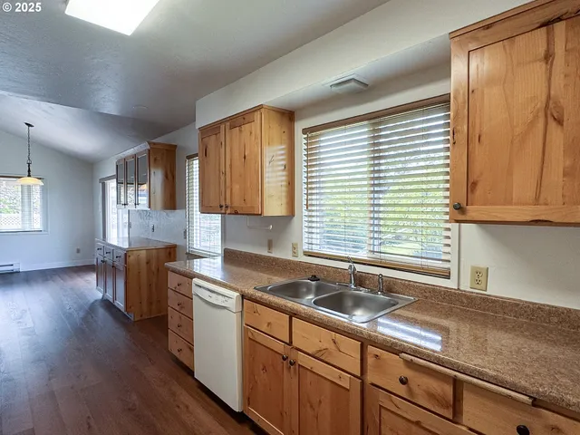 a kitchen with stainless steel appliances granite countertop a sink a stove cabinets and wooden floor