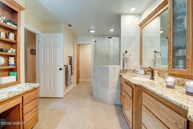 a spacious bathroom with a granite countertop sink and a mirror