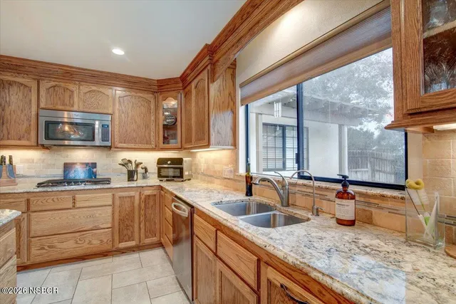 a kitchen with kitchen island granite countertop a sink counter top space and a view of living room