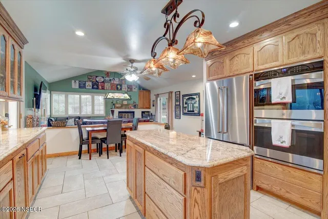 a living room with stainless steel appliances kitchen island granite countertop furniture and a view of kitchen