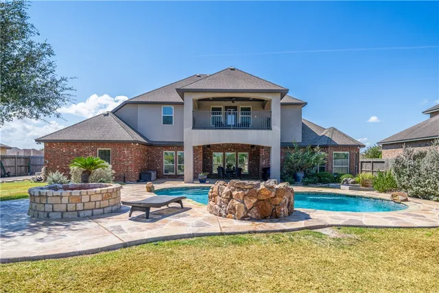 a view of a house with backyard sitting area and garden