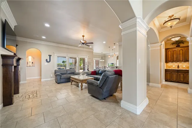 a living room with couches and kitchen view with wooden floor
