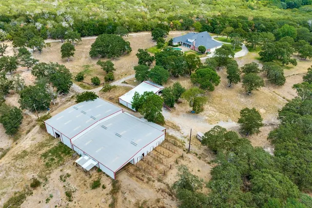 an aerial view of a house with a yard and lake view