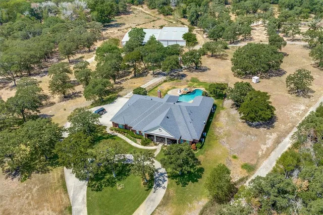a front view of a house with a yard and large trees